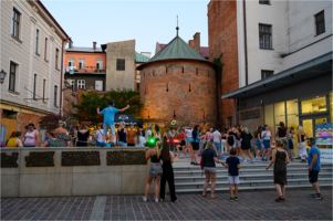 Na zdjęciu osoby tańczące podczas silent disco obok Multimedialnego Centrum Artystycznego