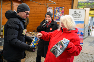 Na zdjęciu osoba wrzucająca datki do puszki podczas bazarku na starówce