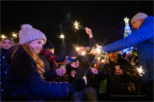 Na zdjęciu bawiący się mieszkańcy podczas imprezy sylwestrowej, trzymają zimne ognie
