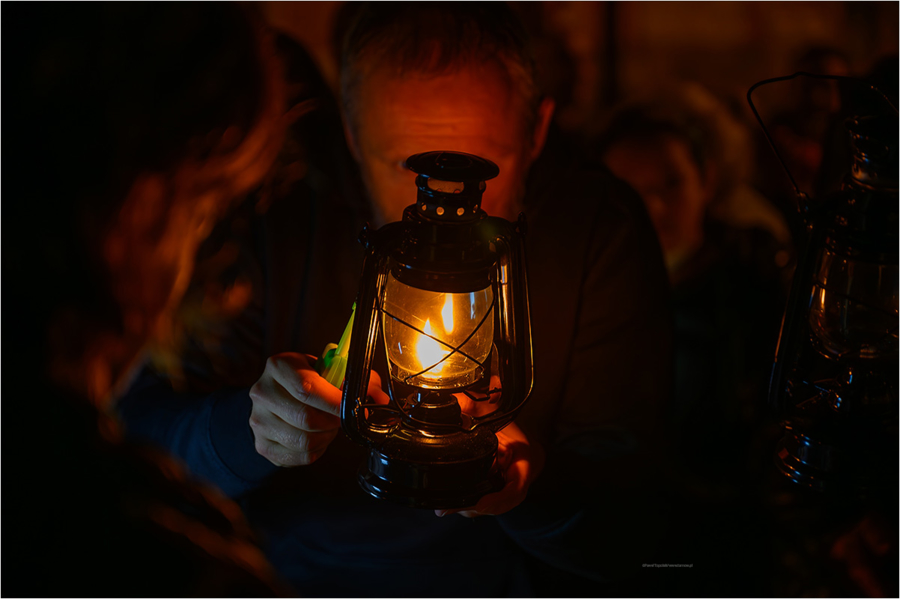 Na zdjęciu mężczyzna podpalający lampion